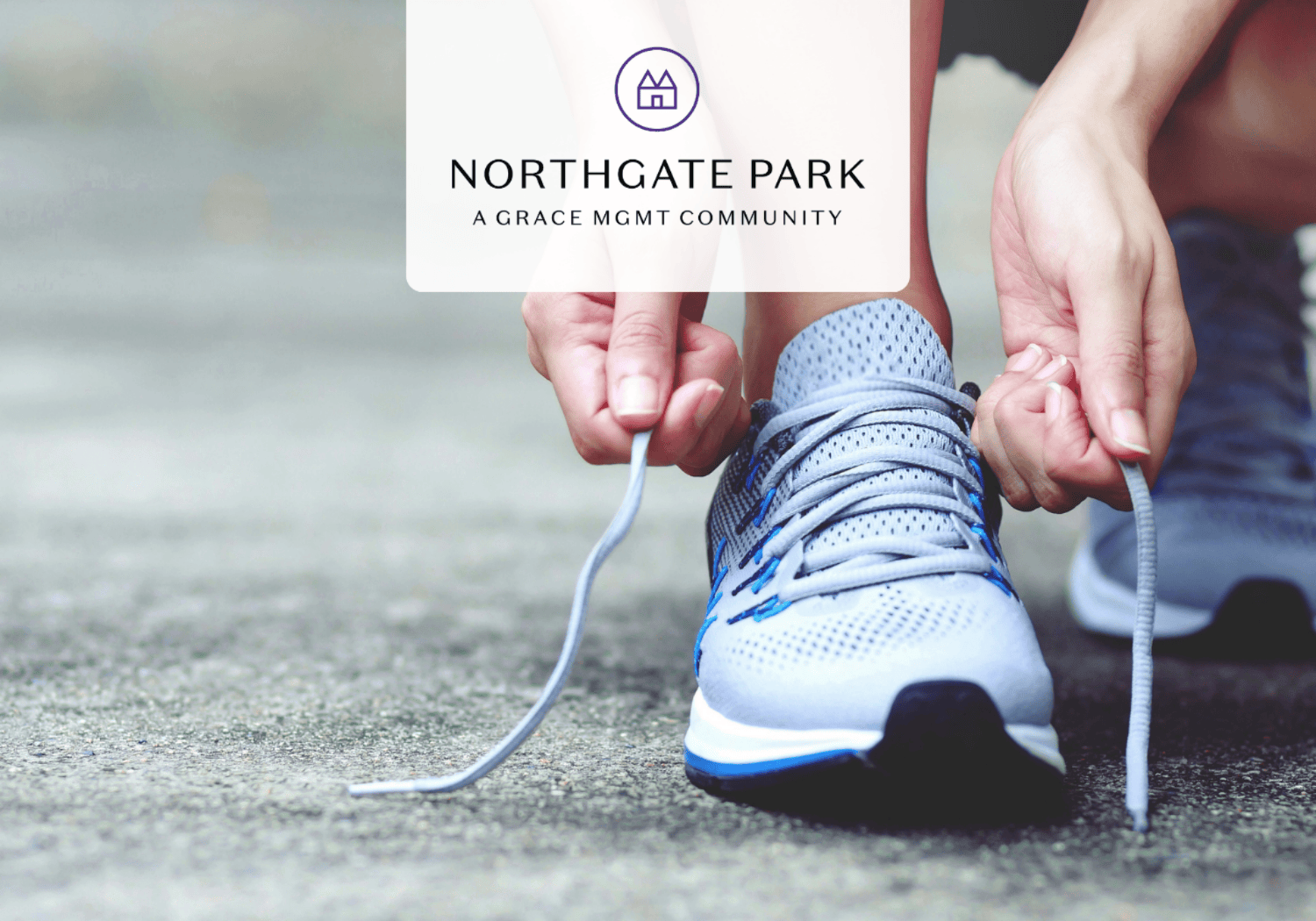 Person tying the laces of a blue athletic shoe on a paved surface with a Northgate Park logo overlay above.